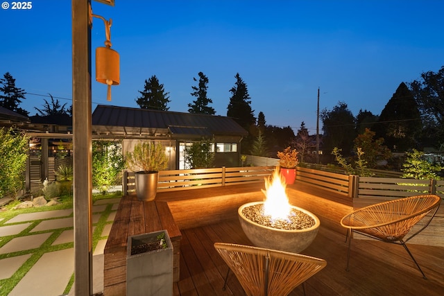 wooden terrace featuring an outdoor fire pit