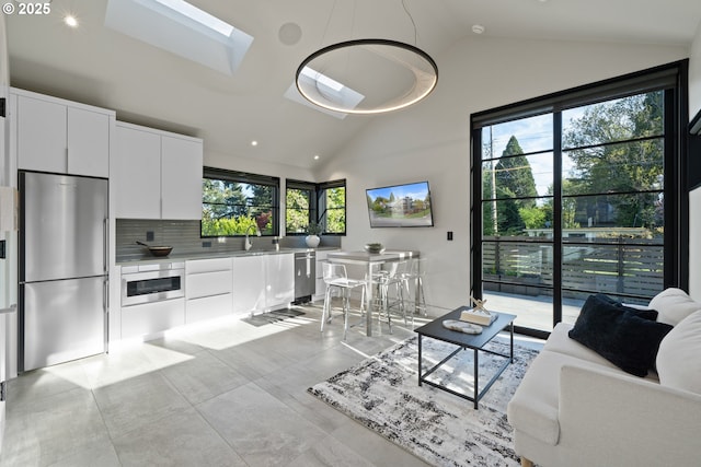 living room with a skylight, high vaulted ceiling, and recessed lighting
