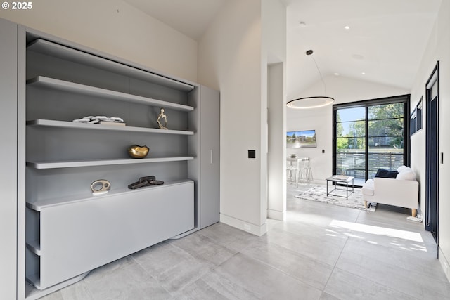 corridor with baseboards, built in features, and vaulted ceiling
