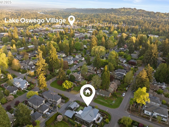 birds eye view of property featuring a residential view and a wooded view