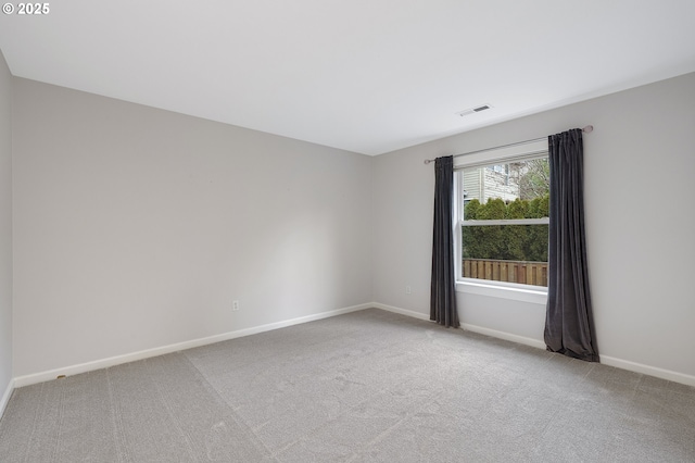 carpeted spare room featuring visible vents and baseboards