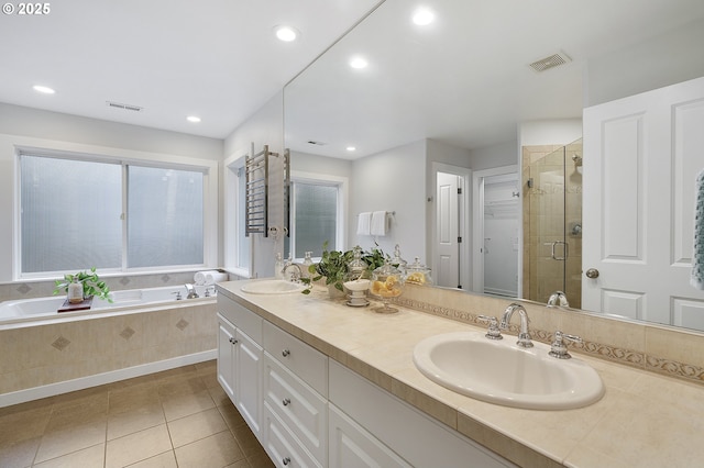 bathroom featuring a stall shower, visible vents, a sink, and a bath