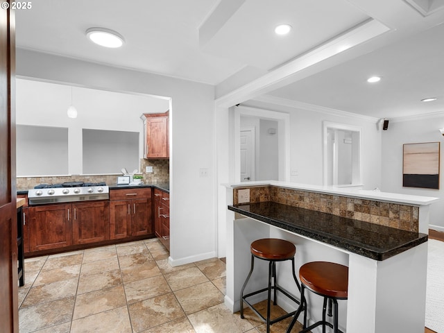 8920 SW 9th Dr, Portland, OR 97219 - kitchen with stainless steel gas stovetop, tasteful backsplash, a kitchen bar, dark countertops, and crown molding