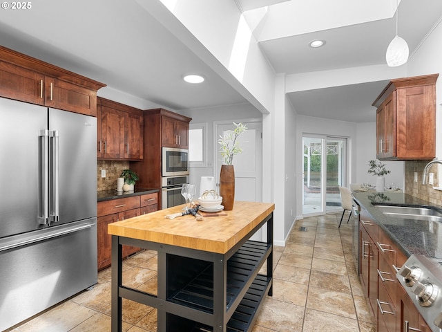 8920 SW 9th Dr, Portland, OR 97219 - kitchen with appliances with stainless steel finishes, a sink, decorative backsplash, recessed lighting, and dark stone countertops