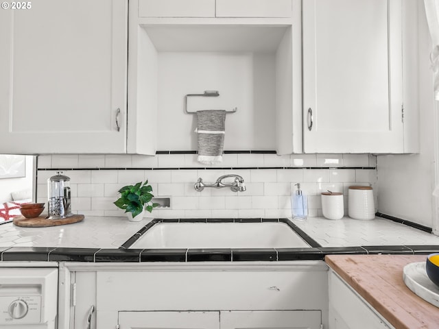 kitchen with sink, backsplash, and white cabinets