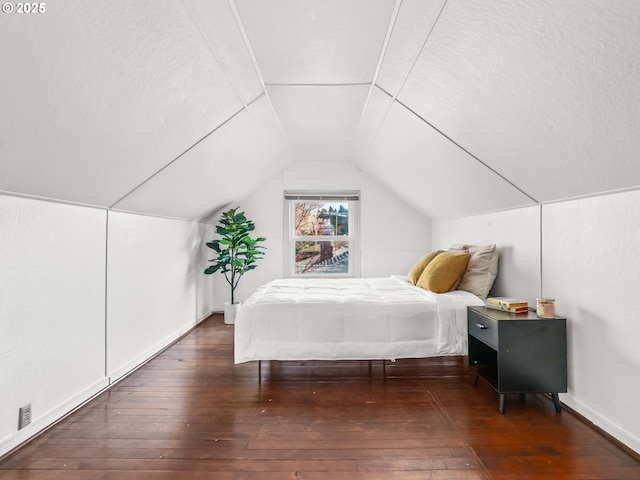 bedroom with vaulted ceiling and dark wood-type flooring