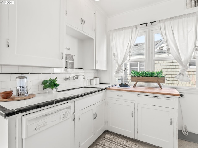 kitchen with white dishwasher, sink, white cabinetry, and backsplash