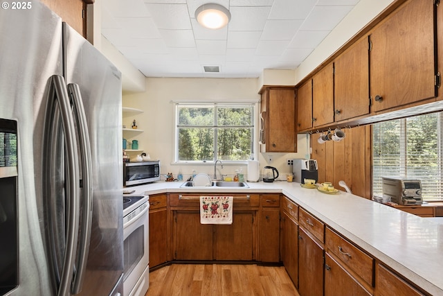 7291 Rice Valley Rd, Oakland, OR 97462 - kitchen featuring stainless steel appliances, light wood-type flooring, brown cabinets, and light countertops
