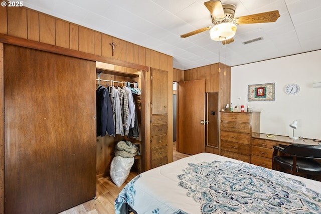 7291 Rice Valley Rd, Oakland, OR 97462 - bedroom with a closet, light wood-style floors, wood walls, and ceiling fan