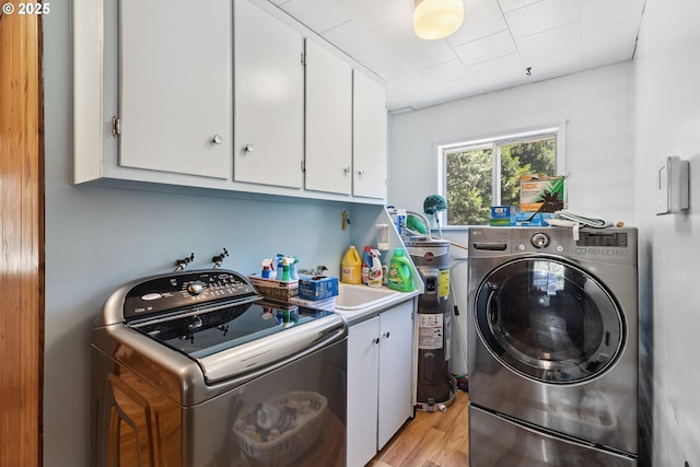7291 Rice Valley Rd, Oakland, OR 97462 - laundry room featuring cabinet space, separate washer and dryer, electric water heater, and light wood-style floors