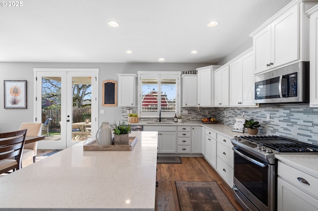 kitchen with sink, white cabinetry, stainless steel appliances, a center island, and french doors