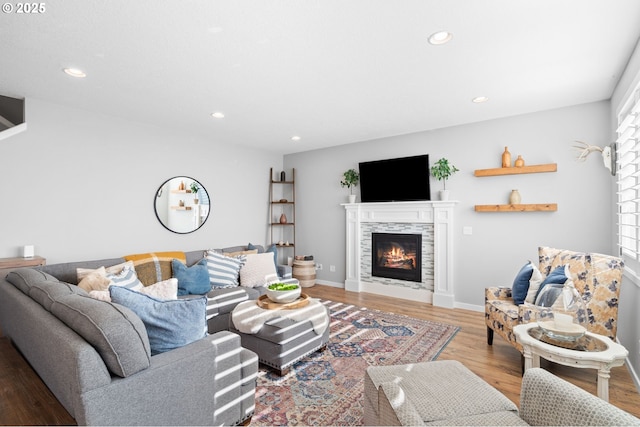 living room featuring a tiled fireplace and hardwood / wood-style floors