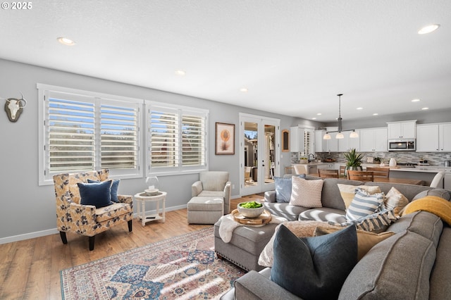 living room with french doors and light wood-type flooring