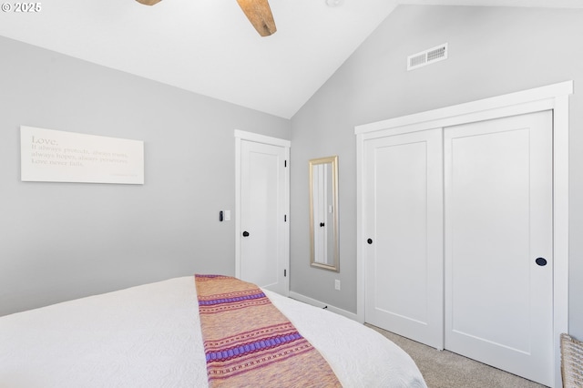 bedroom featuring lofted ceiling, light colored carpet, ceiling fan, and a closet