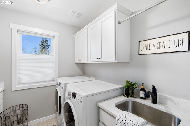 laundry room with cabinets, sink, and washing machine and dryer