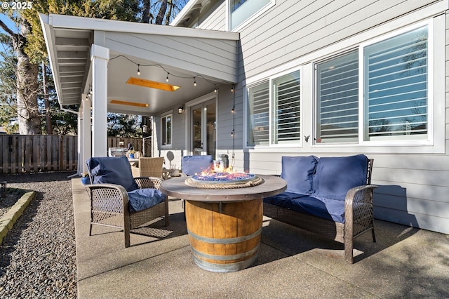 view of patio with an outdoor living space with a fire pit