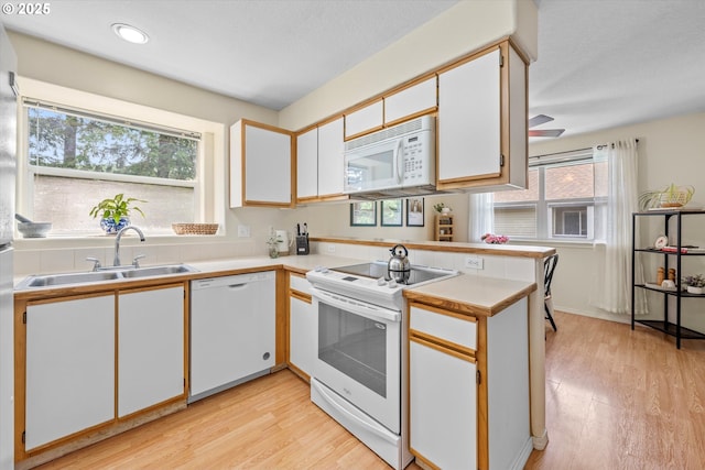 4728 W Powell Blvd Unit 231, Gresham, OR 97030 - kitchen with white appliances, a sink, light countertops, light wood finished floors, and recessed lighting