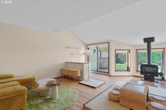 13802 NW 10th Ct, Vancouver, WA 98685 - living room featuring a wood stove, wood finished floors, vaulted ceiling, and a textured ceiling