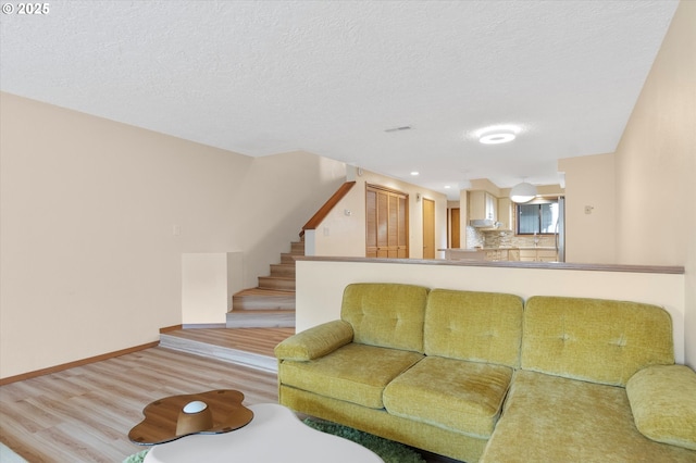 13802 NW 10th Ct, Vancouver, WA 98685 - living area with stairway, light wood-style flooring, baseboards, and a textured ceiling