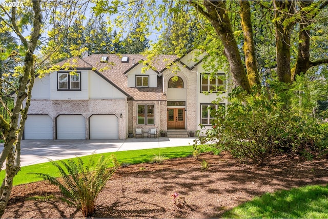 8751 SW 194th Pl, Beaverton, OR 97007 - view of front facade with brick siding, roof with shingles, concrete driveway, french doors, and a garage
