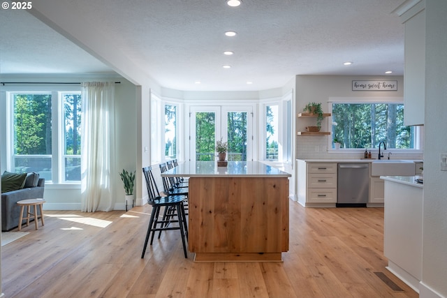 8751 SW 194th Pl, Beaverton, OR 97007 - kitchen with stainless steel dishwasher, white cabinets, recessed lighting, light countertops, and a kitchen island