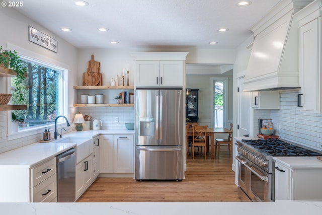 8751 SW 194th Pl, Beaverton, OR 97007 - kitchen featuring appliances with stainless steel finishes, open shelves, premium range hood, recessed lighting, and tasteful backsplash