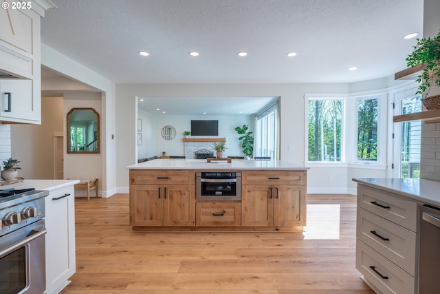 8751 SW 194th Pl, Beaverton, OR 97007 - kitchen featuring stainless steel appliances, recessed lighting, light countertops, light wood-type flooring, and a textured ceiling
