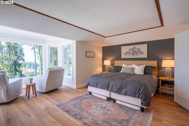 8751 SW 194th Pl, Beaverton, OR 97007 - bedroom with a textured ceiling, light wood-type flooring, and a raised ceiling