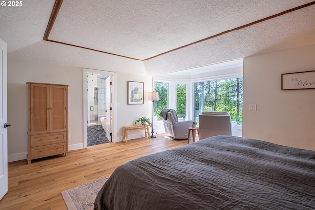 8751 SW 194th Pl, Beaverton, OR 97007 - bedroom with a textured ceiling, light wood-style flooring, and connected bathroom