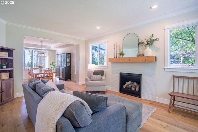 8751 SW 194th Pl, Beaverton, OR 97007 - living area featuring plenty of natural light, light wood-style flooring, crown molding, recessed lighting, and a brick fireplace