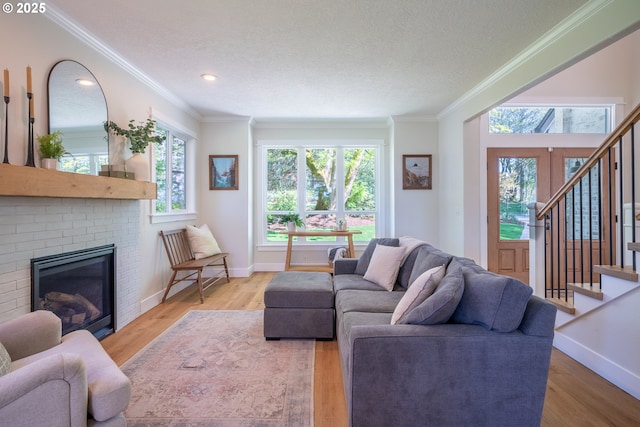 8751 SW 194th Pl, Beaverton, OR 97007 - living room featuring ornamental molding, a brick fireplace, stairway, wood finished floors, and a textured ceiling