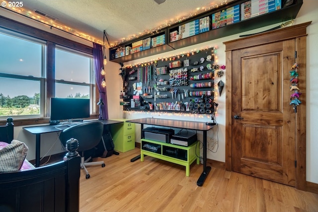 office space featuring wood finished floors, a textured ceiling, and a dry bar