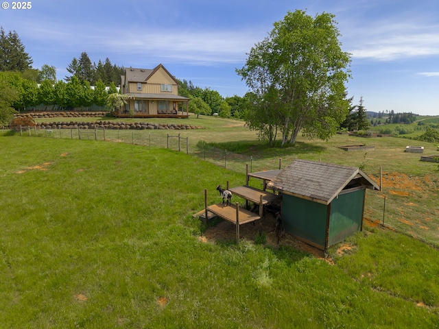 view of yard with an outdoor structure, a storage shed, and a rural view