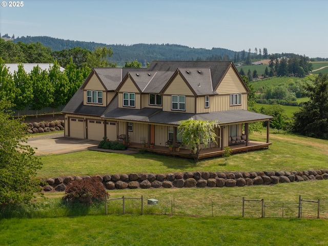 view of front facade featuring driveway, an attached garage, board and batten siding, a forest view, and a porch