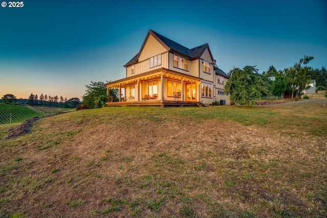 back of house at dusk with a yard