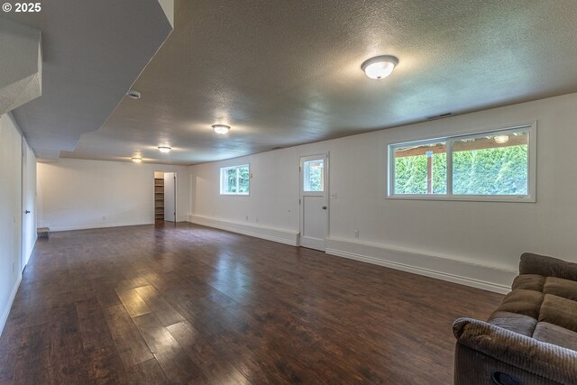 3026 NW Norwood St, Camas, WA 98607 - unfurnished living room with dark wood-type flooring, a textured ceiling, baseboards, and healthy amount of natural light