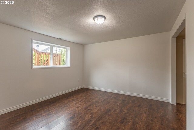 3026 NW Norwood St, Camas, WA 98607 - empty room featuring dark wood-style floors, a textured ceiling, and baseboards
