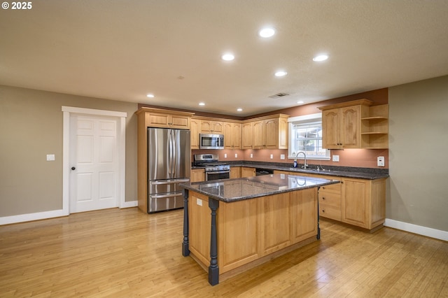 50 W Taylor St, Carlton, OR 97111 - kitchen featuring appliances with stainless steel finishes, a sink, baseboards, a center island, and light wood-style floors
