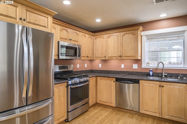 50 W Taylor St, Carlton, OR 97111 - kitchen featuring stainless steel appliances, a sink, light wood-type flooring, recessed lighting, and dark stone counters