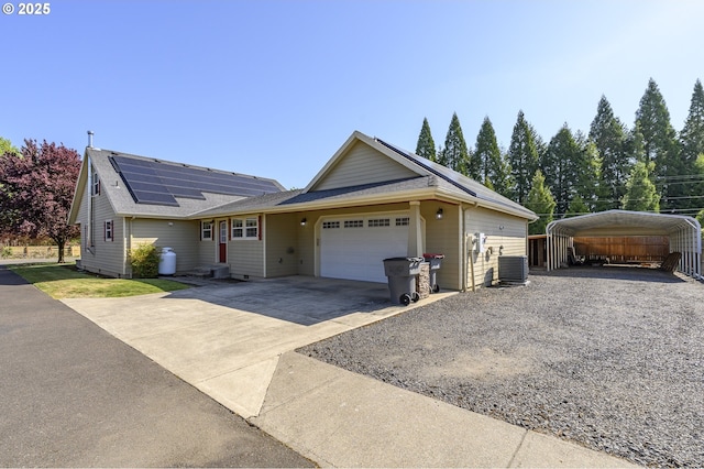 50 W Taylor St, Carlton, OR 97111 - ranch-style home featuring concrete driveway, central air condition unit, a detached carport, an attached garage, and roof mounted solar panels