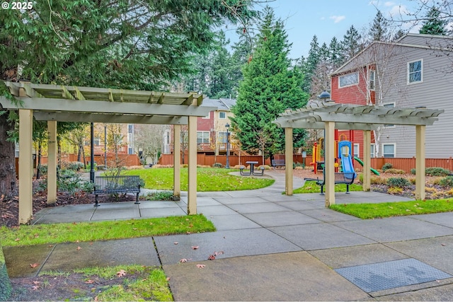 view of community with a playground, a yard, and a pergola