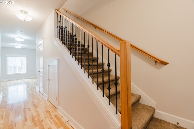 stairway with baseboards and wood finished floors