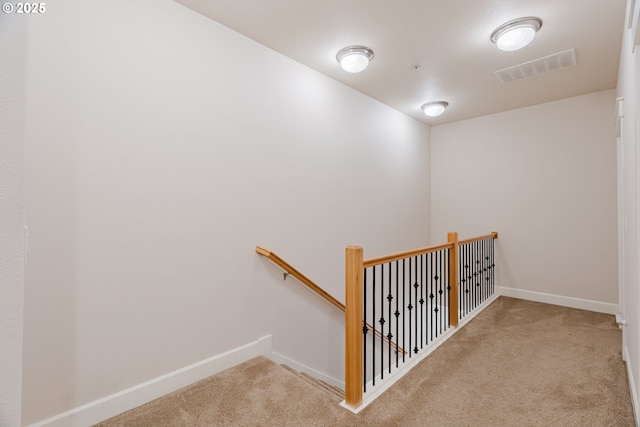 staircase featuring carpet floors, baseboards, and visible vents