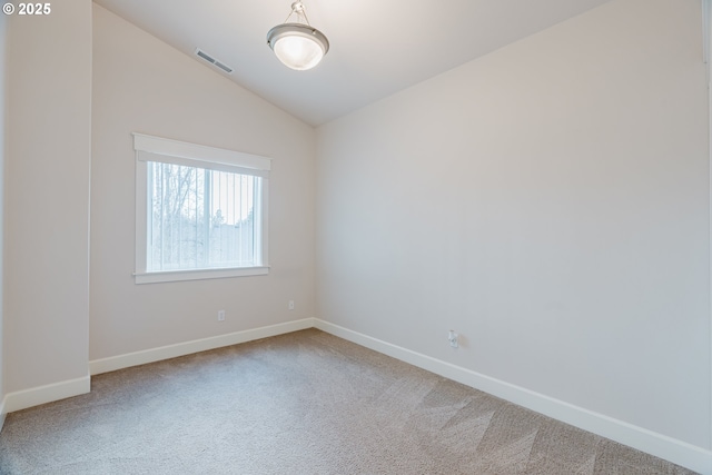 carpeted empty room featuring lofted ceiling, baseboards, and visible vents