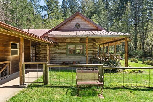 exterior space featuring a porch, log siding, and metal roof