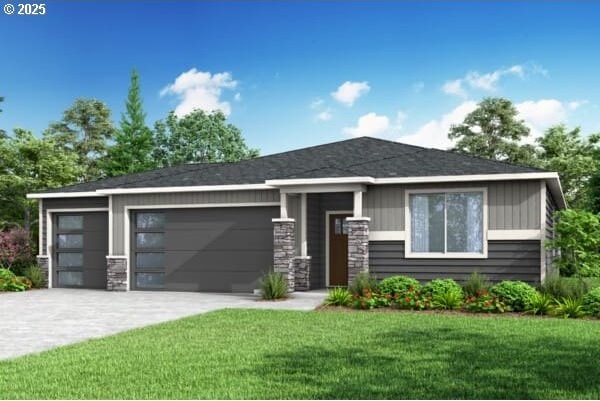 view of front facade with a garage, a front yard, concrete driveway, and stone siding