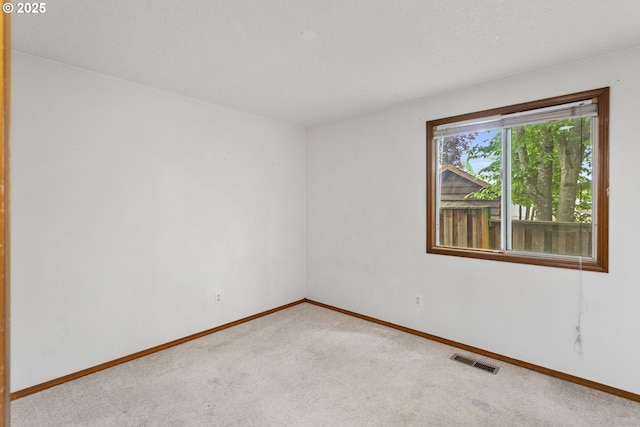 carpeted empty room featuring baseboards