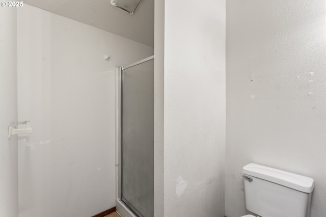 bathroom featuring toilet and a shower stall