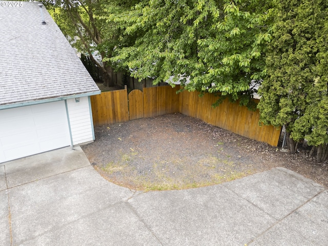 view of patio / terrace with fence and a garage
