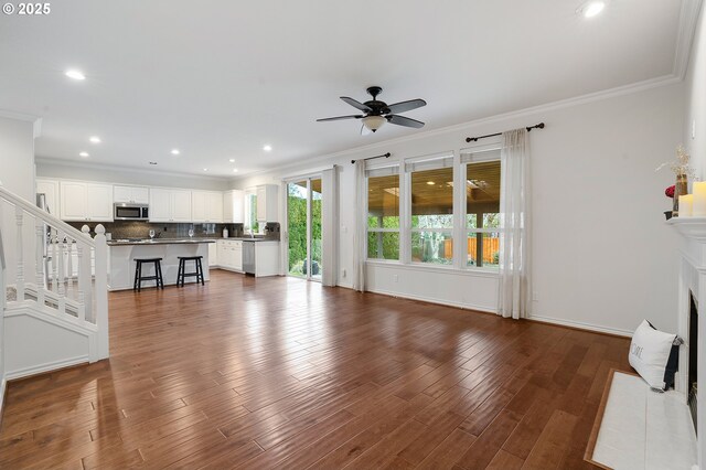 living room featuring ceiling fan, crown molding, and dark hardwood / wood-style floors